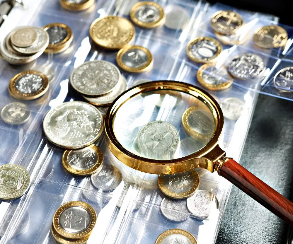 Magnifying glass examining various coins collection.