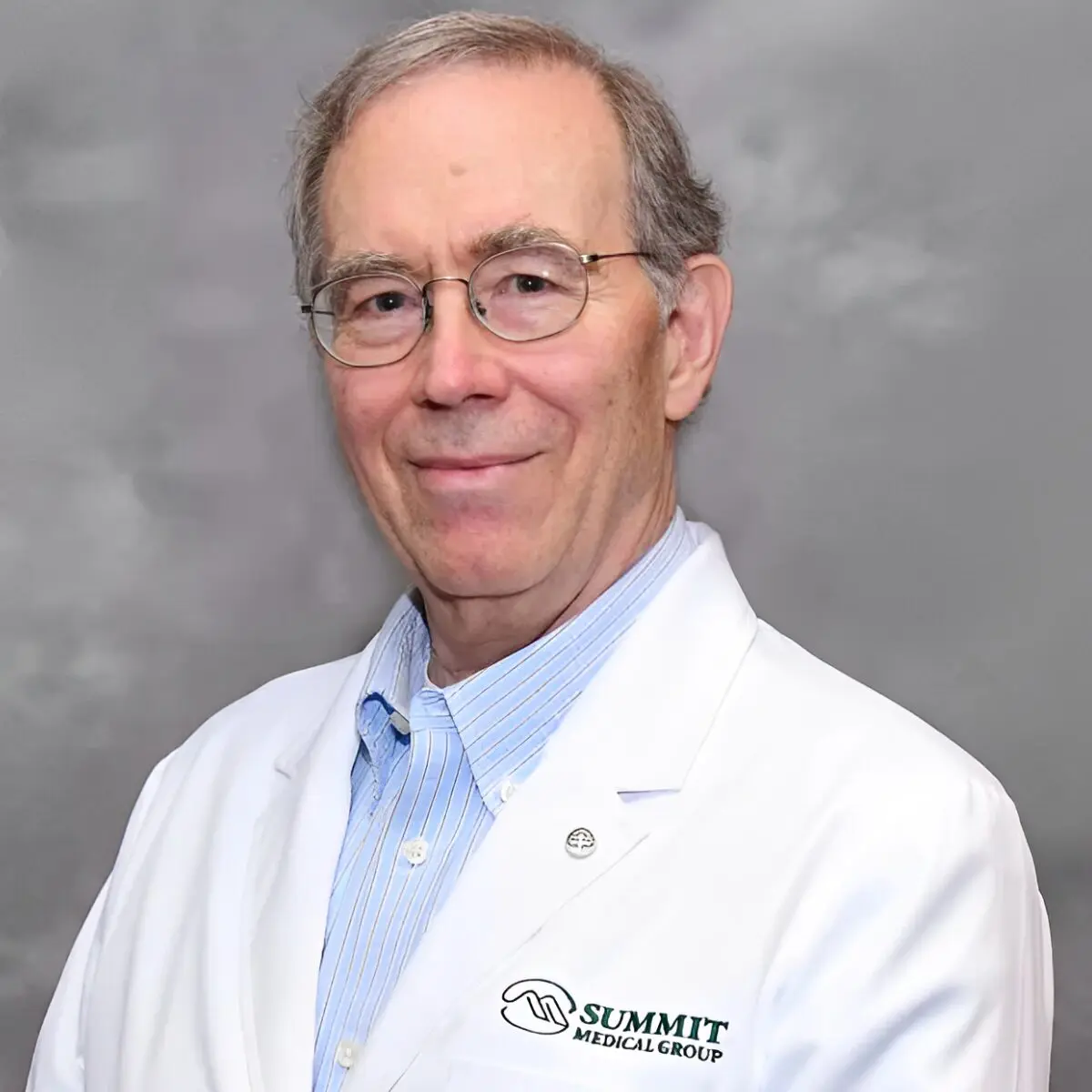 Man in white lab coat smiling.