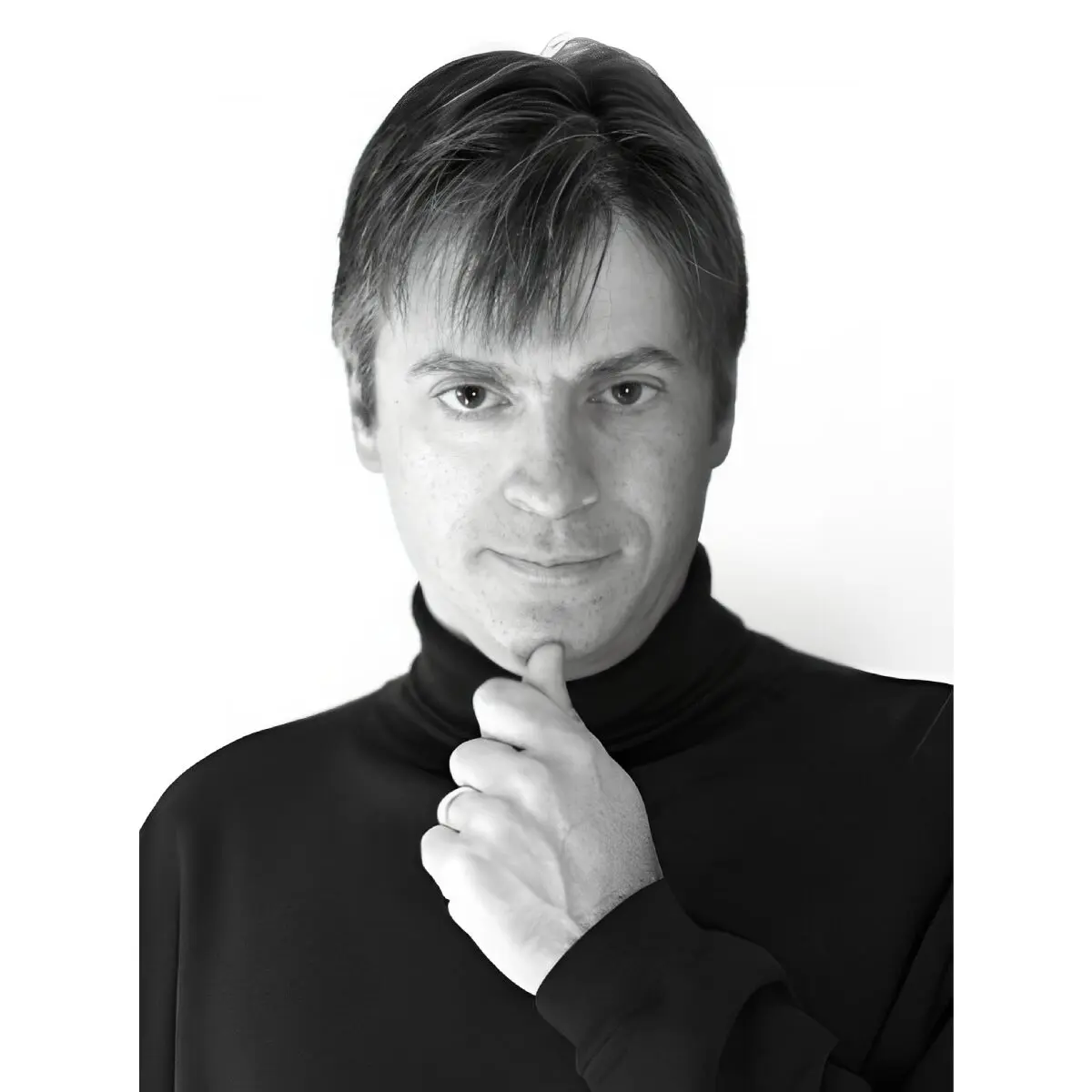 Man in black turtleneck, thoughtful expression.