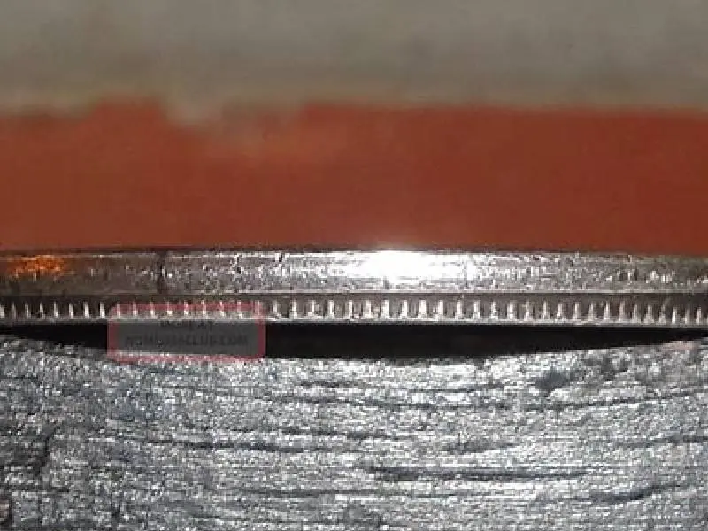 Close-up of a coin's edge showing detailed ridges.