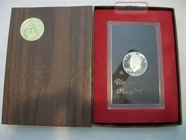 Silver commemorative coin in wooden display case.