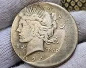 1924 silver coin held in gloved hand.