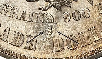 Close-up of coin with arrows pointing.