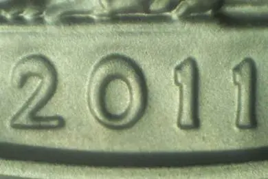 Close-up of numbers '201' embossed on a metallic surface.