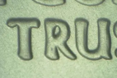 Close-up of embossed letters forming the word 'TRU'.
