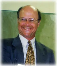 Smiling man in a suit and glasses.
