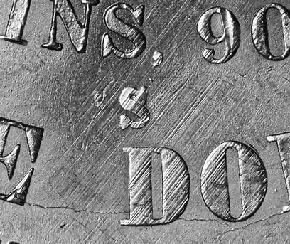 Close-up of engraved coin letters and numbers.