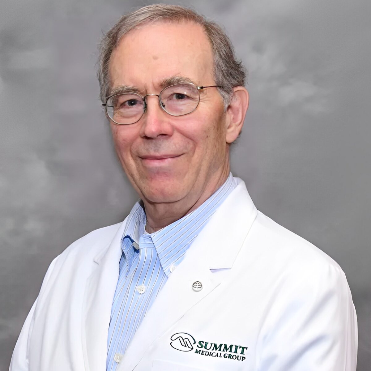Man in white lab coat smiling.