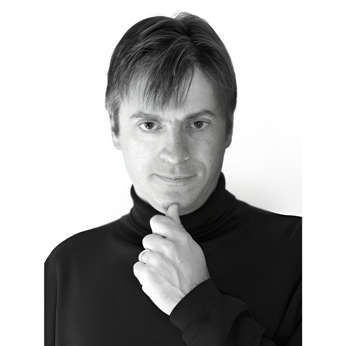 Man in black turtleneck, thoughtful expression.