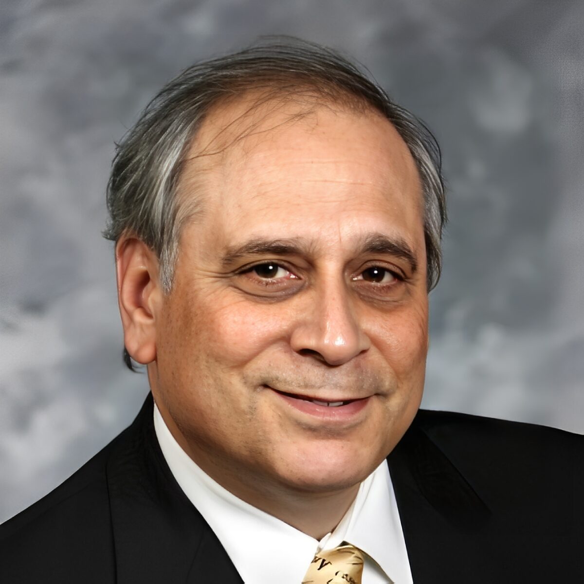 Man in suit with a neutral expression.