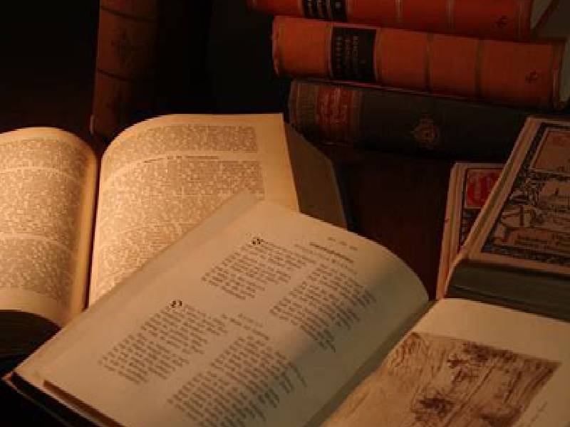 Open books on a table with warm lighting.