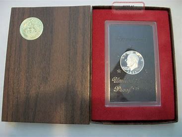Silver commemorative coin in wooden display case.