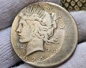 1924 silver coin held in gloved hand.